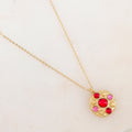 Collier doré avec pendentif rond embelli de 5 pâtes de verre roses et rouges