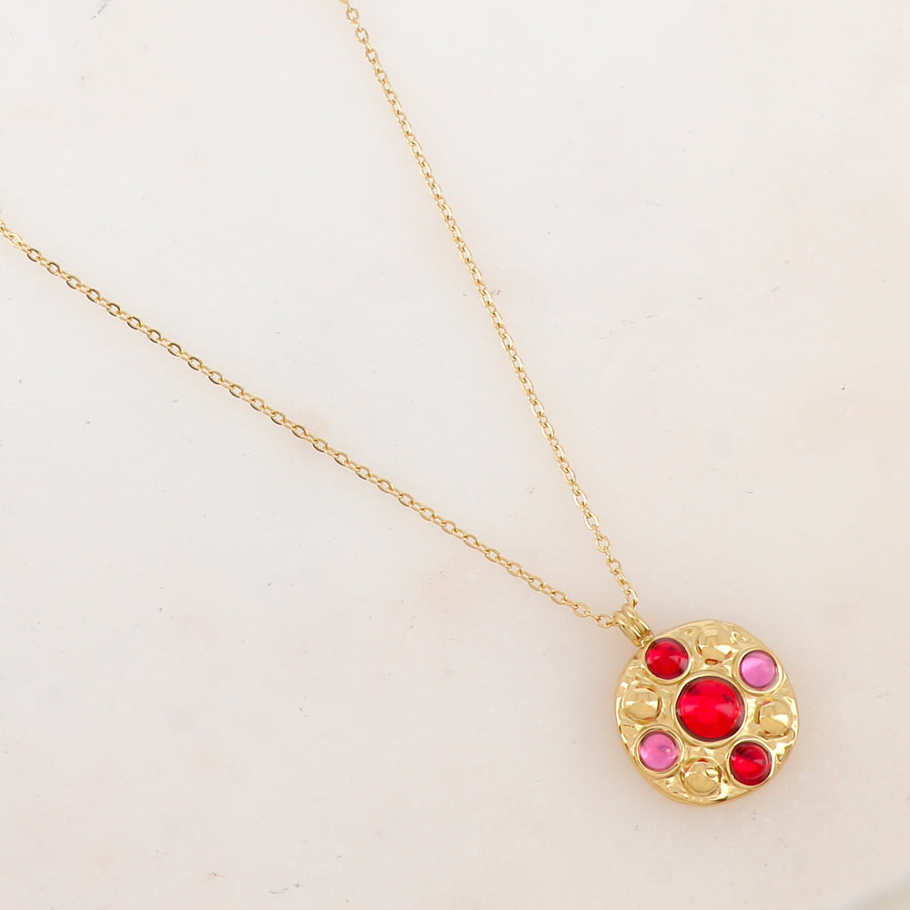 Collier doré avec pendentif rond embelli de 5 pâtes de verre roses et rouges
